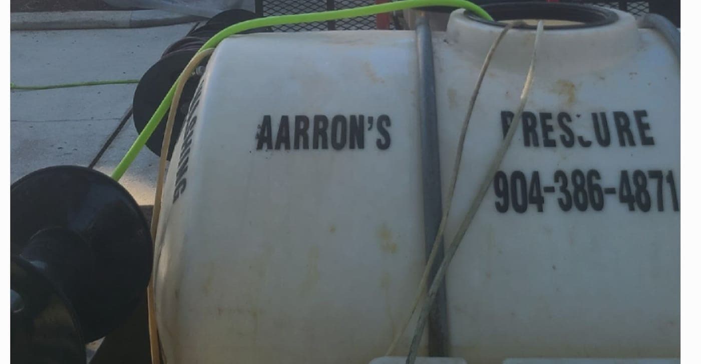 The company name and phone number lettered on Aarron's water tank.