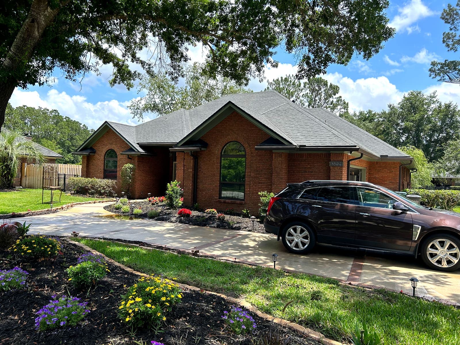 A brick home in Jacksonville with a freshly cleaned concrete driveway under a clear sky.