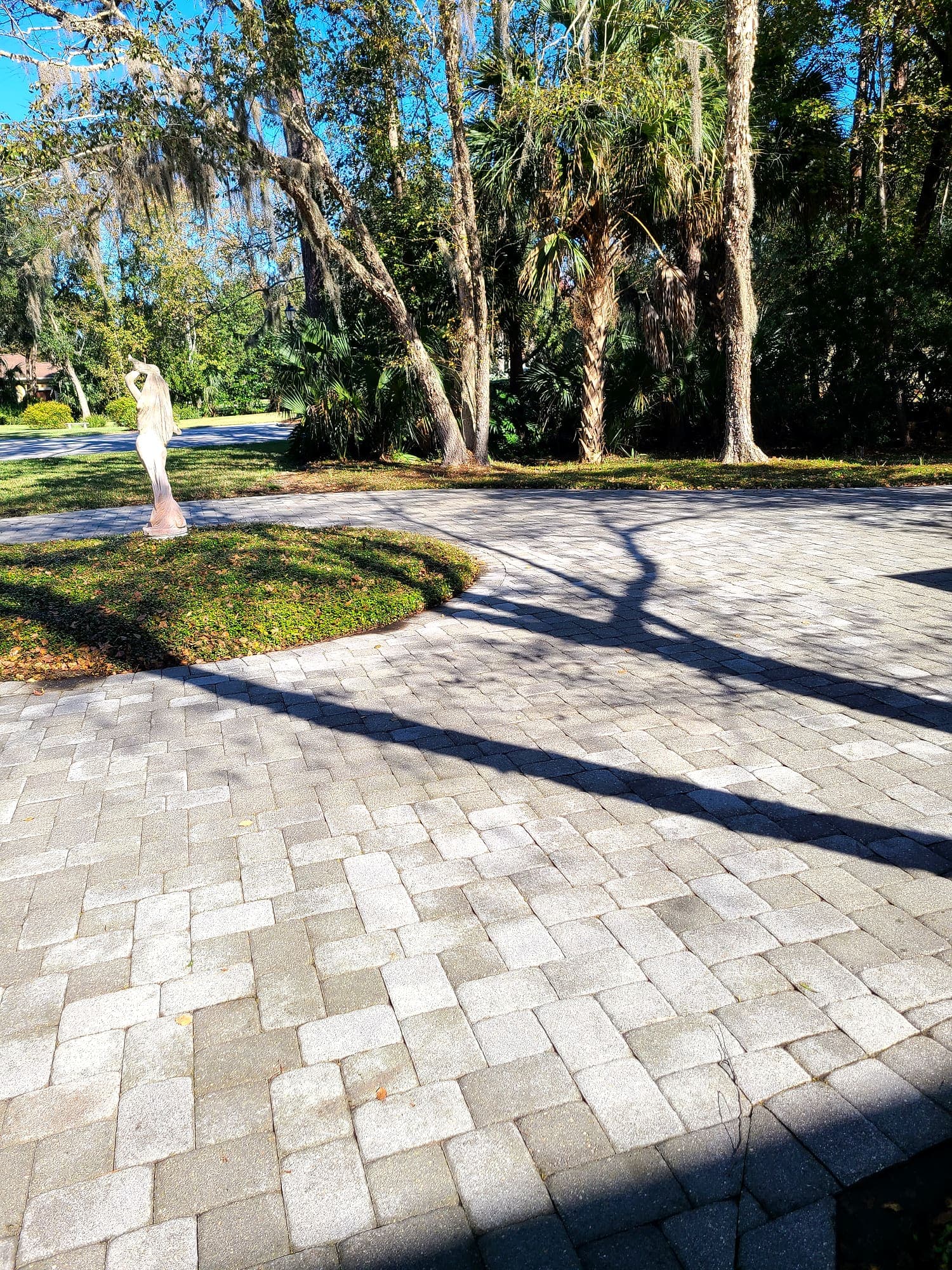 The same paver driveway cleaned, the tan and gray of each paver visible again.